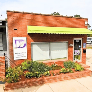 Exterior view of the Washington Street Community Enrichment Center with a brick facade, green awning, and landscaped front garden.