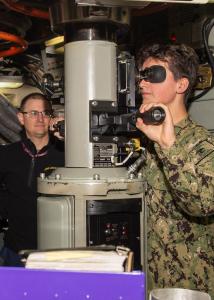 A Sea Cadet peers through a submarine periscope during hands-on training.