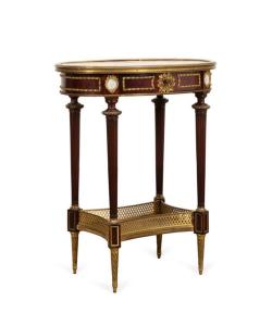 Louis XVI style marble-top gueridon table in the manner of Henry Dasson (French, 1825-1869), with ormolu mounts, round jasperware plaques, and turned fluted legs ($4,840).