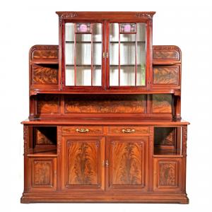 Important Louis Majorelle buffet deux corps (sideboard display cabinet), carved with a grapevine motif, with stained glass panels with metal grapevine overlay. Estimate: $4,000-$6,000.