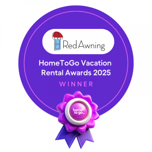 A purple winner ribbon with RedAwning's logo designating them as the winner of HomeToGo's 2025 Vacation Rental Awards