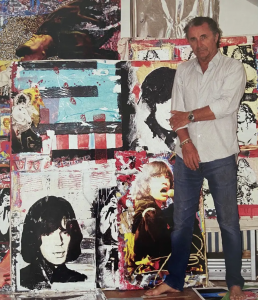 Award-winning photographer and mixed-media artist Steve Joester stands in front of his wall of art