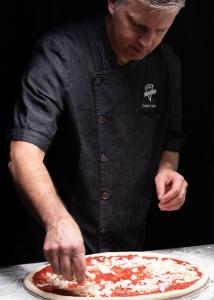 Chef topping the Sbarro Pizza with Shredded Mozzarella Cheese