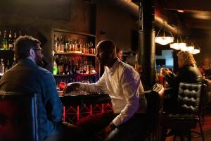Still image of Dylan Mooney and Jesse Metcalfe sitting in a bar talking from the movie THE COMIC SHOP (photo by Kayla Bowen)