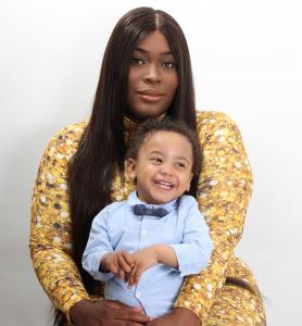 Mother Ezinwanne is holding her son Lion in her arms. He is sitting on her lap smiling joyously