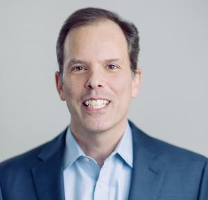 Derek J. Reed, the author is a white man in a blue suit