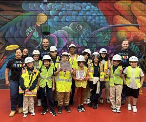 Courtney Kelly poses with students and volunteers during AGC MA's Adopt-a-School event at Mario Umana Academy in Boston