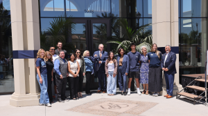 Representatives gather around a large ribbon for the Palomar Health Student Wellness Center ribbon cutting.