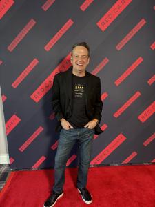 Ray Seggern stands on red carpet at The Red Carpet Society event