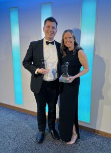 Chris and Carolyn smiling holding the awards