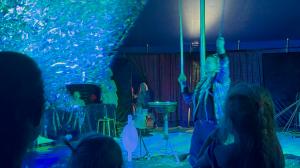 There is a huge foam bubble in a circus arena held up by soap bubble artist Olga