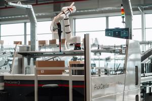 TGW Logistics robotic picking solution, RovoFlex, connected to their PickCenter One order picking workstation for flexible and continuous manual/automatic order fulfillment.