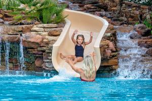 child sliding down pool slide