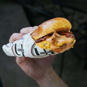 Universal Joint is bringing back its National Burger Day celebration for the second consecutive year, offering Joint Rewards members a free smash burger all day long on Thursday, May 28, 2026 A close-up of Universal Joint’s smash burger with melted cheese, crispy bacon, and sauce, held in a hand and wrapped in UJ-branded paper. This is the free burger guests receive on National Burger Day, May 28, by joining the Universal Joint Loyalty Program