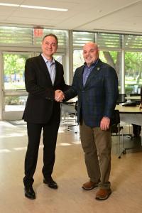 Ashkan Tabibnia, CEO of 90210 Enterprise, and Todd Johnson, President and CEO of Beverly Hills Chamber of Commerce, shaking hands, celebrating their partnership.