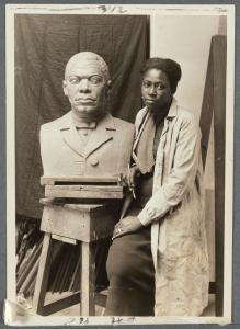 Renowned African American Artist Selma Burke stands with her bust of Booker T. Washington