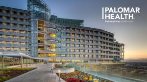 A modern hospital building at sunset.