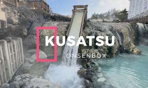 Kusatsu Onsen Box contents displayed, including bath powders, hinoki essential oil, Japanese senbei, and mulberry tea