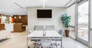 Interior view of a small client meeting space with sightlines to the front desk and patio space outside.