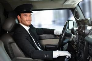 Professional chauffeur loading luggage into AAlimousine black car at JFK Airport, New York" (Describes action, location, and brand; includes keywords like "JFK Airport limousine service".