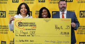 Image of a large donation check held up by two women and one man