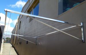 Eco 240 Fold Down clothesline in 316 Stainless Steel mounted to brick wall