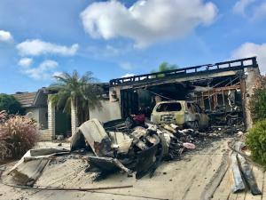 Garage and vehicle severely damaged by a house fire