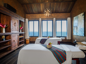 Two tables for couples massage in spa treatment room with Belizean influenced decor and view of Caribbean Sea
