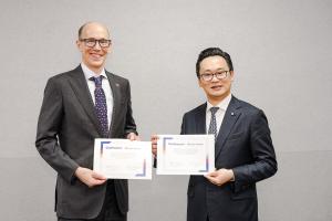 Two men in suits, China Airlines President Han-Ming Chen (right) and Southwest Airlines Chief Operating Officer Andrew Watterson (left), stand side-by-side, holding up a signed partnership declaration. Andrew Watterson, who is Caucasian and wearing glasse