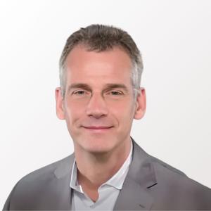 Portrait of Andreas Jeromin, PhD, wearing a light gray suit and white shirt, smiling against a plain white background. GLX Analytix announces his appointment as Consulting Chief Scientific Officer, highlighting his expertise in diagnostics and biomarkers.