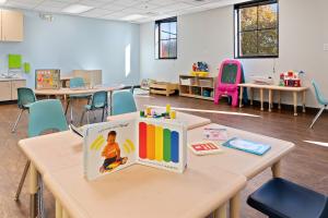 A bright, child-friendly classroom at Bierman Autism Centers with educational toys, sensory books, a pink chalk easel, and activity tables designed for early learning and therapy.