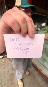 The owner of Sea Eagle market holding up his old paper traceability tag "Jesus Lives" is the boat that landed the shrimp.