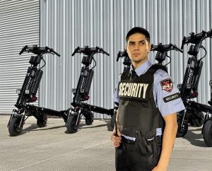 247 Gard security officer in uniform standing in front of a row of electric patrol scooters