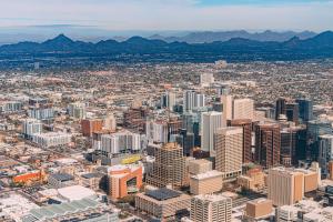 Aerial photograph looking down at downtown Phoenix, showing city buildings, streets, and surrounding landscape.