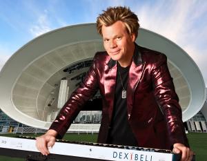 Smooth jazz artist Brian Culbertson poses with a Dexibell VIVO S10 keyboard in front of the iconic Rady Shell at Jacobs Park, setting the stage for the San Diego Smooth Jazz Festival.