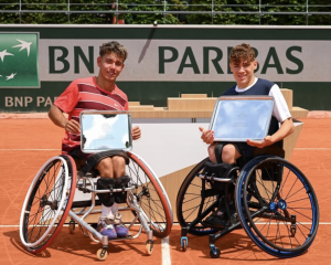 Two boys in tennis wheelchairs, holding up their championship silver plates at Roland Garros 2025.
