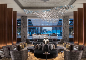 Luxuriously appointed hotel lobby seating area with tall ceilings, view of city