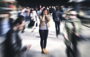Young woman experiencing anxiety and disconnection in a crowded public area—illustrating youth mental health struggles and the need for trauma-informed counselling services in Guelph.