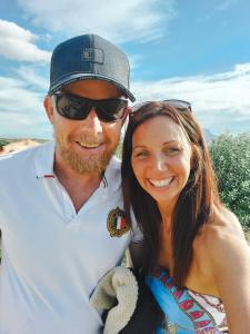 Robyn and Paul Sartorius standing together at the beach, enjoying a moment of relaxation and the freedom they’ve built for their family.