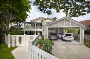 dion seminara architecture continues to see strong demand for its expertise in renovating Queenslander and character homes, which require a careful balance of heritage sensitivity and contemporary liveability Renovated Queenslander home in Hawthorne with white picket fence, timber detailing, and new carport, designed by Dion Seminara Architecture.