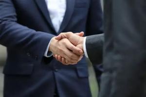 Two telcom C-level professionals shaking hand on a partnership agreement