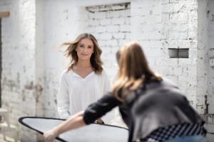 Photographer adjusts lighting reflector during an outdoor corporate headshot session, capturing a confident and approachable professional portrait.