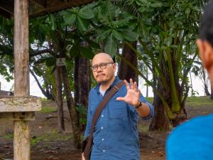 Khun Athikhom, the Sustainability Consultant, cycling through a lush green path during the guided cultural bike tour to Moklen Village.