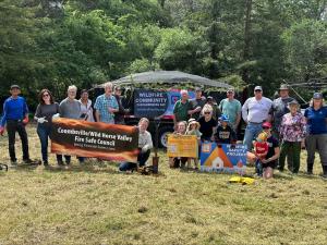 Group of neighbors gather to help clean up debris and create defensible space around community building