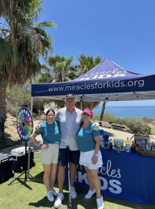 Tim Ryan (center), Retired CEO Honda Center & Anaheim Ducks, takes a break from the Stars and Stripes Golf Tournament with Miracles for Kids staffers Sapphira Roberson and Laura Collins
