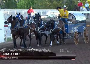 A team of four horses pulls a wagon at the Calgary Stampede chuckwagon races. A label from the broadcast reads, Chad Fike, Steelhaus Tryton.