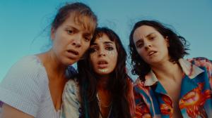 three women react with surprise in a photo from the movie