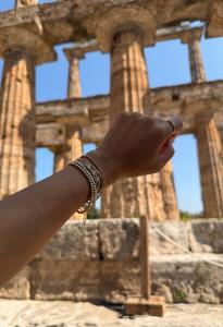 Velani Jewelry founder shows her favorite bracelet stack at ancient ruins of Temple of Hera in Paestum, Italy