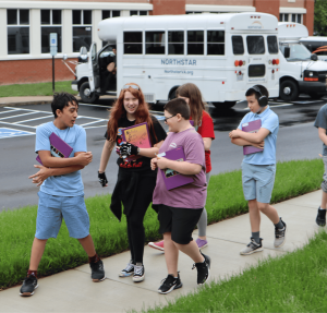 A group of Northstar middle school students laughing and talking as they walk together from the gymnasium back to class.