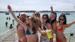Group of girls celebrating and having fun on a private tiki boat tour with Crab Island Journeys.